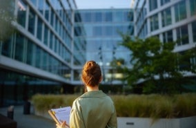 A woman holding a bunch of documents.