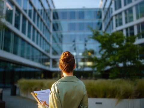 A woman holding a bunch of documents.